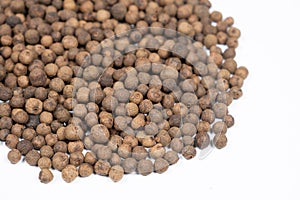 Black peppercorns close-up on white background