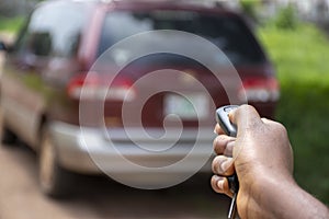 Black person using a car remote to unlock a car