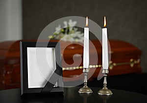 Black photo frame  burning candles on table in funeral home
