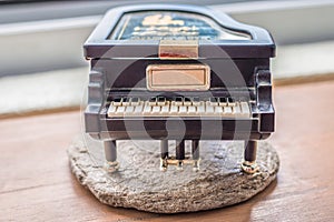 Black piano music box on wooden table