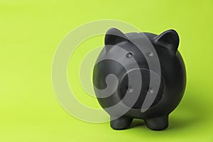 Black piggy bank on color background