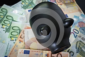 Black piggy bank on pile of Euro banknotes as saving concept