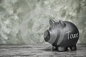 Black piggy bank with word TAXES