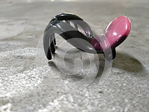 The black and pink colour of an object is occurring in the right side of aluminium texture