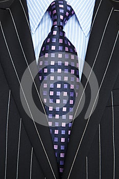 Black pinstripe suit and purple tie