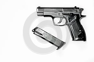 A black pistol with a magazine for cartridges lies on a white background