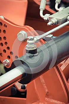 Black piston or actuator in red pneumatic or hydraulic machine. Technology