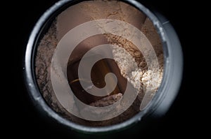Black plastic jar with a sports supplement protein. On a black background