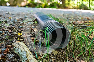 Black plastic pipe lying discarded in nature..