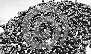 black plastic polymer granules on white background