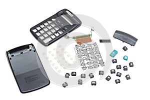 A black plastic scientific calculator dismantled showing all its internal parts