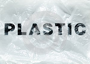Black Plastic word on transparent white disposable plastic bag. Environment pollution problem concept image with copy space