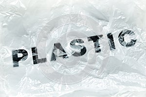 Black Plastic word on transparent white disposable plastic bag. Environment pollution problem concept image with copy space
