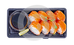 Black plate with rolls with salmon and soy sauce, Japanese cuisine