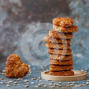 Black plate tower of heart shape cookies grey concrete background. Square.