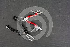 Black pliers and red folding multifunctional tool for anglers.