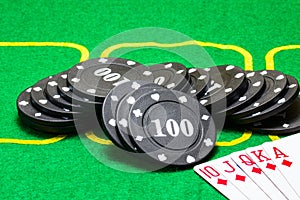 Black poker chips and a strong card combination royal flush