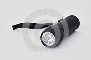 Black poket LED flashlight on white photo