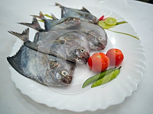 Black Pomfret Decorated with Vegetables and Herbs photo