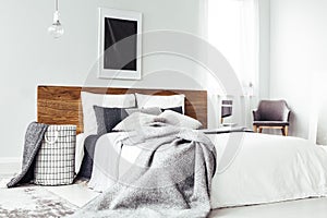 Black poster above wooden bed