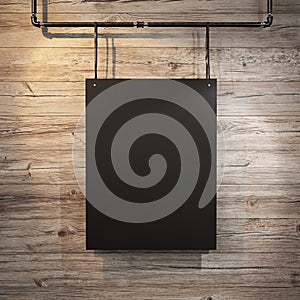 Black poster hanging on leather belt on wood background