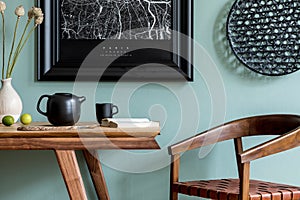Black poster map in frame and kitchen accessories in stylish dining room.