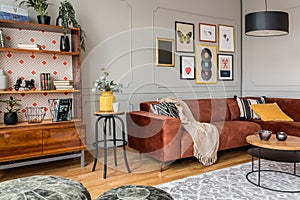 Black poufs in trendy eclectic living room interior with brown couch