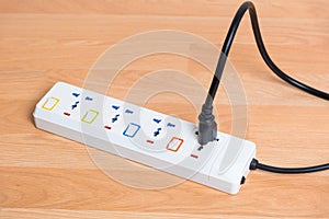 Black power line plug in white socket electric power bar