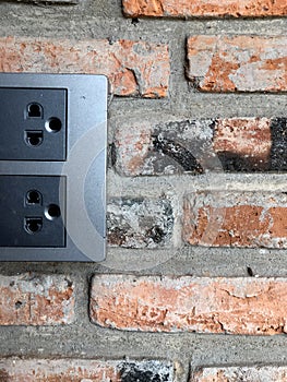 Black power plug Asia plug socket on brick wall background.