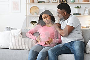 Black pregnant woman suffering from labor pains at home