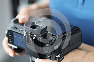 Black professional camera in female hands closeup