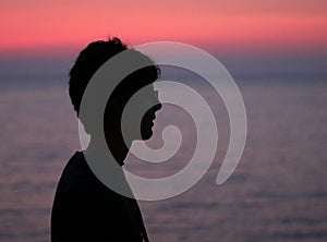 Black profilo of young boy at sunset photo