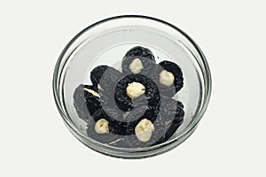 Black Prunes with cheese in a glass plate
