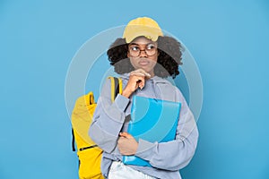 Black puzzlement woman posing with backpack and folder