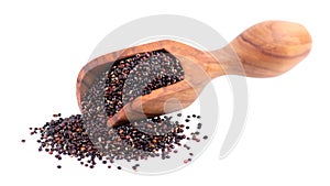 Black quinoa seeds in wooden scoop,  on white background. Pile of raw kinwa.