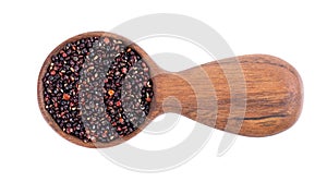 Black quinoa seeds in wooden spoon, isolated on white background. Pile of raw kinwa. Top view.