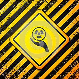 Black Radioactive in hand icon isolated on yellow background. Radioactive toxic symbol. Radiation Hazard sign. Warning