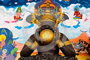 Black rahu statue with golden moon photo