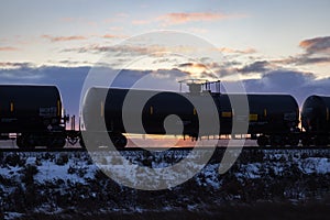 Black Railroad Tank Car Silhouetted at Sunset