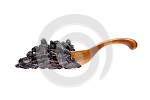 Black raisins in the wooden spoon, isolated on white background.
