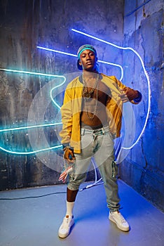 Black rapper in underpass neon light on background