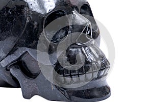 Black realistic carved stone skull with Astrophyllite blades from Russia, isolated on white