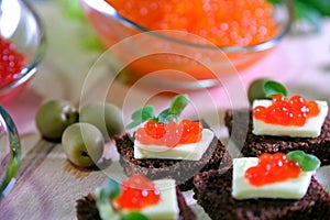 Black red caviar on sandwiches, decorated with greenery. Restaurant food breakfast dinner lunch