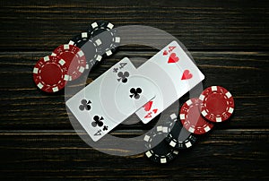 Black and red chips and playing cards with a winning combination of one pair on a black vintage table. Low key concept of winning