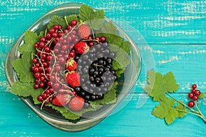 Black, red currant and strawberries on old background. Top view. Close-up