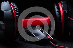 Black-red headphones and a black-red gaming mouse lie on a black background