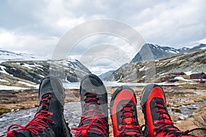 Black and red mountain hiking boots towards mountain scenery