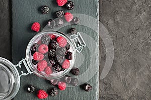 Black and red raspberries in glass jar