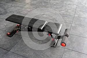 Black and red reinforced flat inclined weights bench. Bench for weight training with weights and dumbbells
