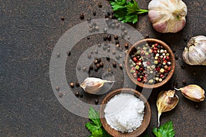 Black, red and white peppersalt, salt, garlic in a wooden bowl . Classic spices for cooking.